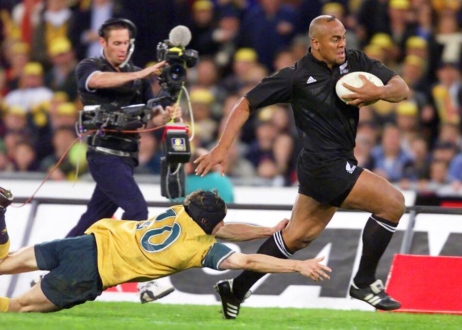 Might and power: Jonah Lomu evades Stephen Larkham during the memorable 39-35 win over the Wallabies at Stadium Australia in July, 2000. Photo: Craig Golding