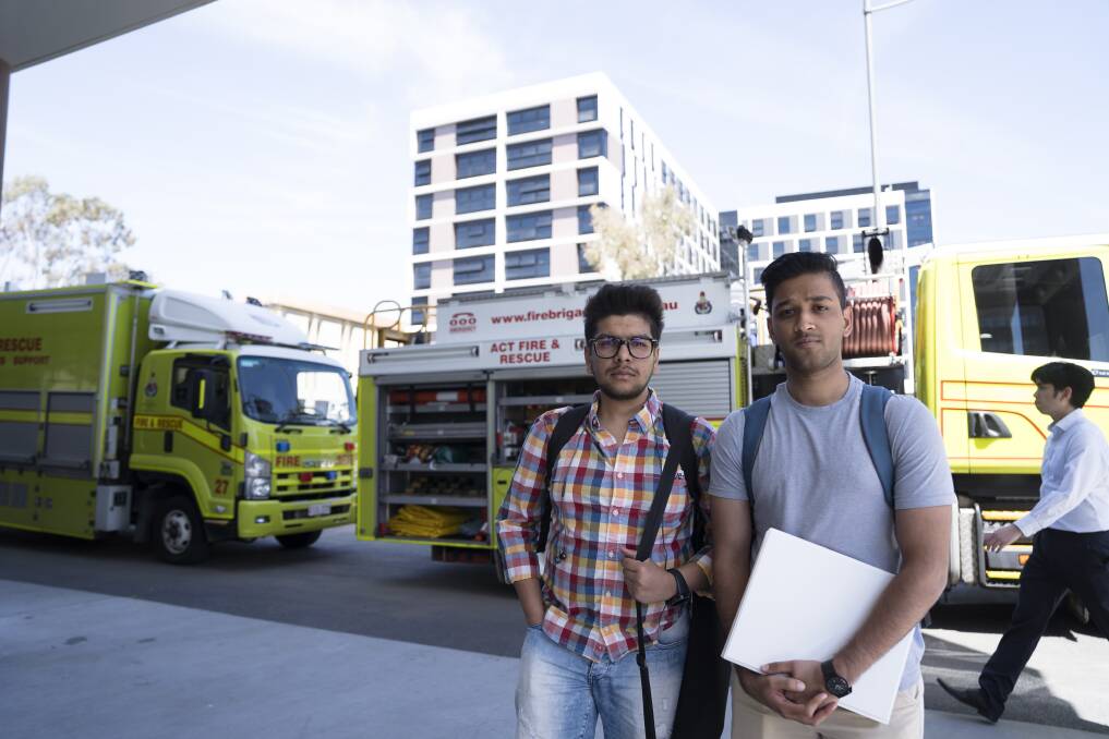 Cooper Lodge residents Aditya Jain (left) and Mudit Bhandari after they were evacuated from their residence, with police cordoning off the area Photo: Lawrence Atkin