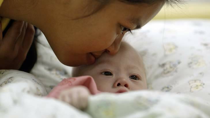 Surrogate mother Pattaramon Janbua kisses baby Gammy. Photo: Reuters