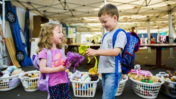 Christopher, 5, and Charlotte, 3, Davies from Campbell look through the remaining toys at the Vinnies Monster Warehouse Sale in Mitchell. Photo: Rohan Thomson