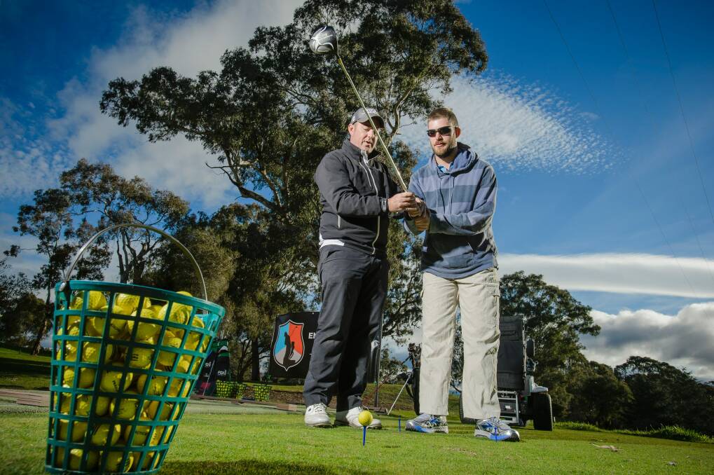 Empower Golf Australia head coach Lachy Foulsham gives a client some tips during an Empower Golf Australia clinic held at the Federal Golf Club on Tuesday. Photo: Sitthixay Ditthavong Photo: Sitthixay Ditthavong