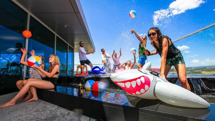 Zoo Advertising Group have their roof-top pool Christmas party. Sophia Kochinos, right, enjoys a refreshing splash during a hot Canberra day. Photo: Katherine Griffiths