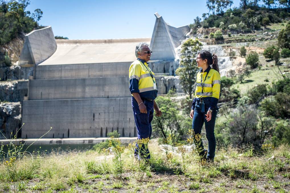 Icon Water water industry operator Siva Preeyadarshanan and operations process engineer Alice Liao discuss the Googong Dam water level in front of the dry spillway. Photo: Karleen Minney