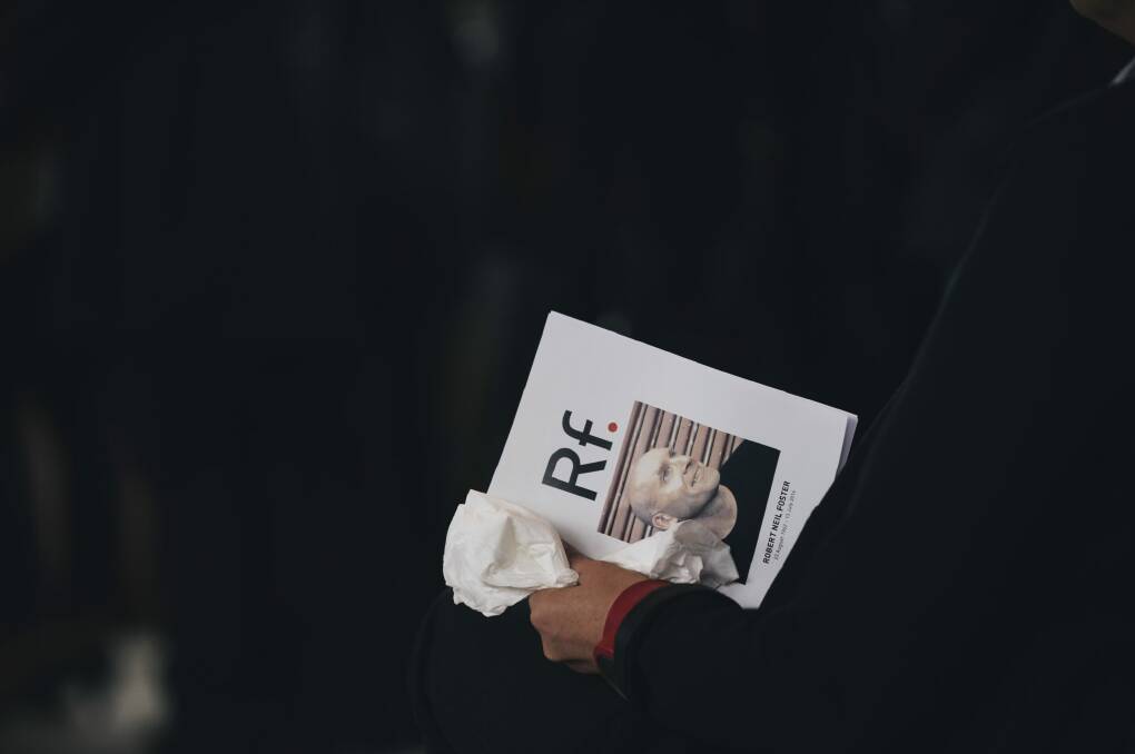 A mourner with the program for the funeral. Photo: Rohan Thomson