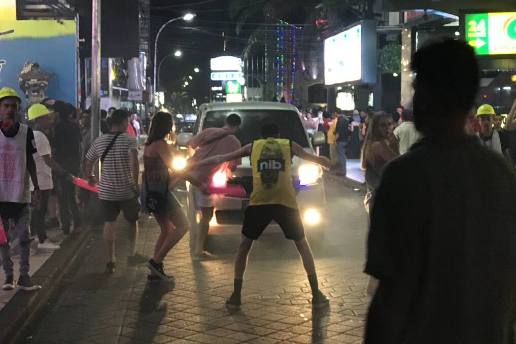 Young, drunk Australian revellers stop traffic on Jalan Legian, Kuta, outside some of the strip's many night clubs.  Photo: James Massola