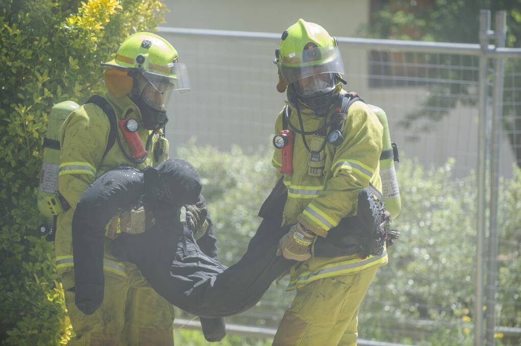 Saved: ACT Fire and Rescue crew carry a ''survivor'' to safety. Photo: Jamila Toderas