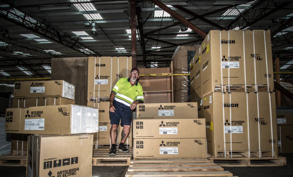Harvey Norman Fyshwick warehouse manager Robert Mason, pictured among the air conditioners,
says there has been a run on the units in the hot weather. Photo: Karleen Minney
