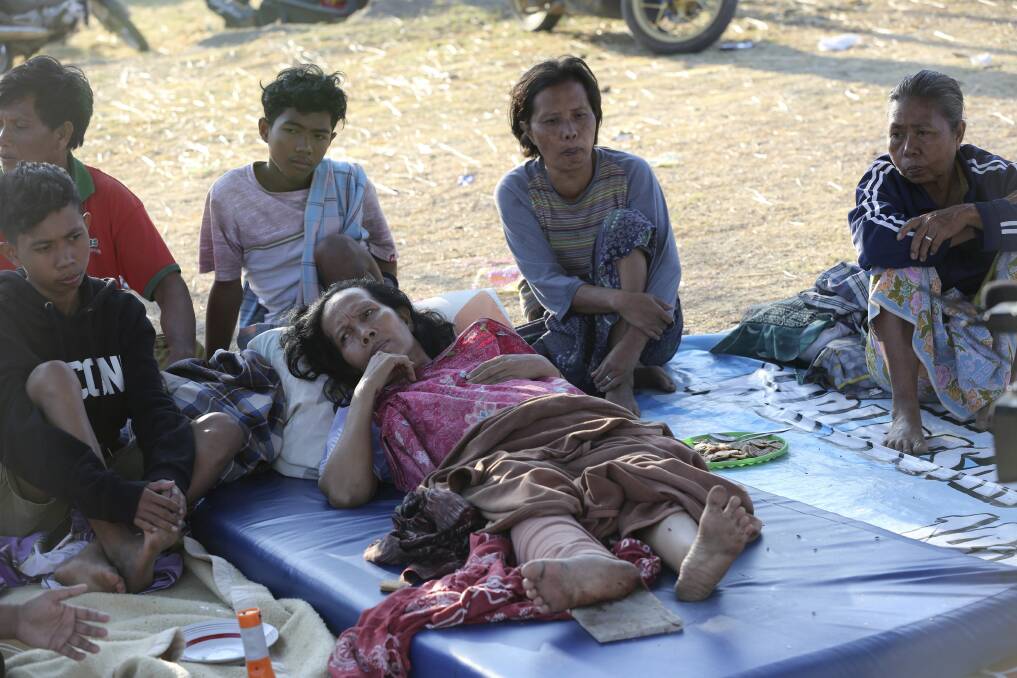 An injured woman lies at a temporary shelter in North Lombok.  Photo: AP