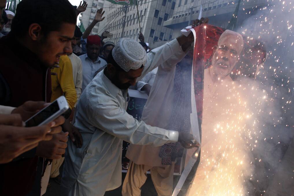 Demonstrators burn a poster of Narendra Modi, India's prime minister, during an anti-India protest in Karachi, Pakistan. Photo: Bloomberg