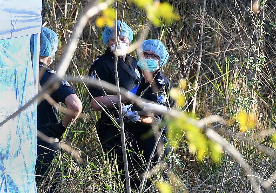 Police forensic officers inspect a crime scene where human remains were found. Photo: Dan Peled
