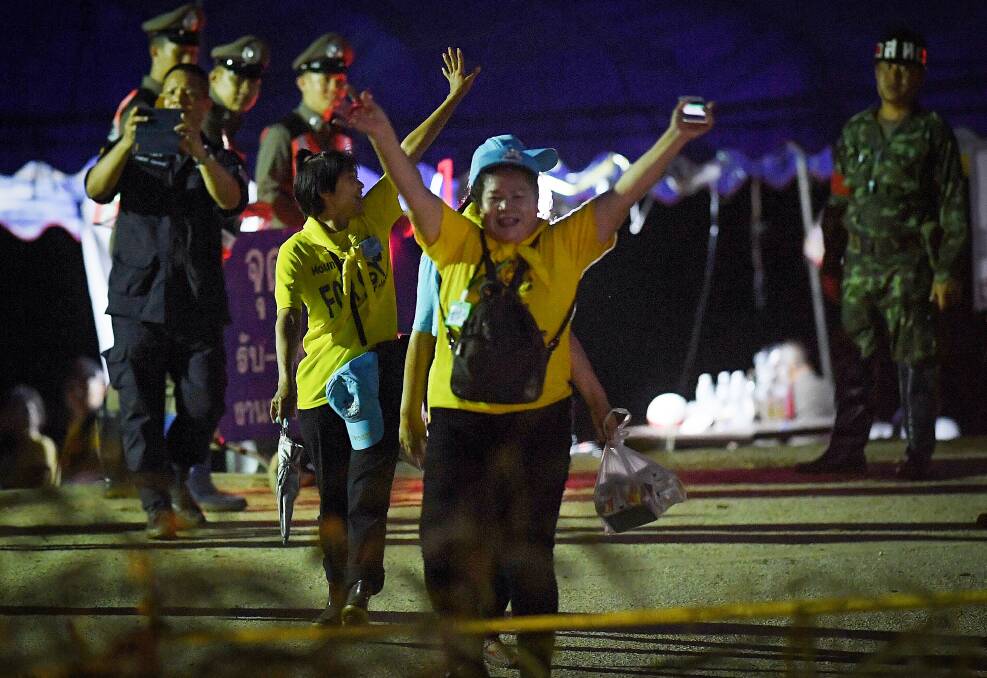 Thai volunteers cheering as they return from Tham Luang cave after all 13 have been rescued.  Photo: Kate Geraghty