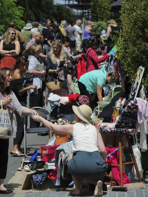 The Suitcase Rummage event at New Acton. Stall-holder Kate Paull, of Kambah, right, makes a sale.

 Photo: Graham Tidy