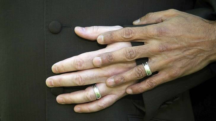 Close up of male homosexual couple wearing wedding rings. Photo: Supplied