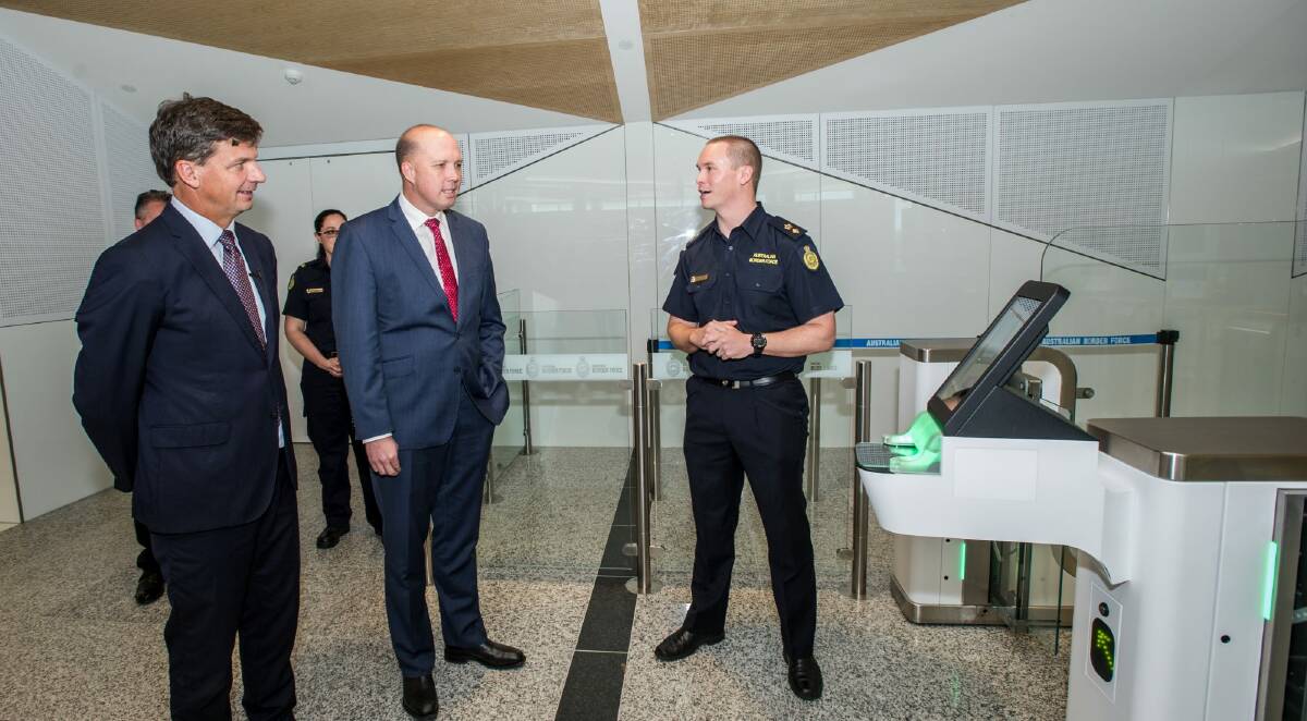 Ministers Angus Taylor and Peter Dutton check out one of the old SmartGates in the international departure lounge at Canberra Airport. Photo: Karleen Minney
