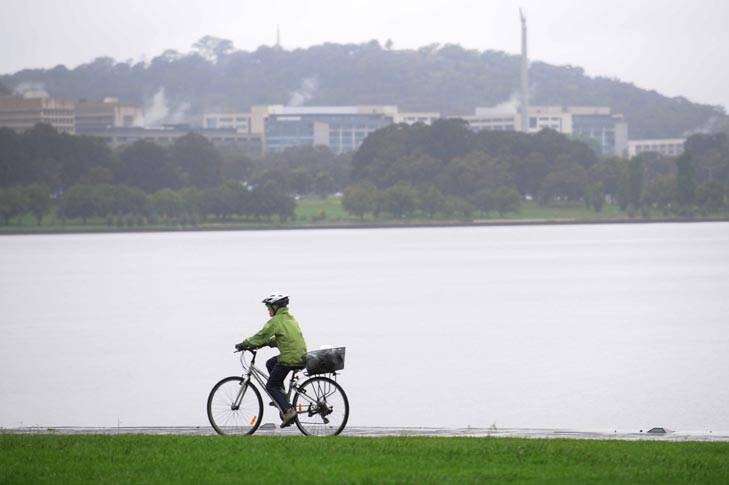 Break in the rain ... a cyclist braves the wet weather around the lake. Photo: Rohan Thomson