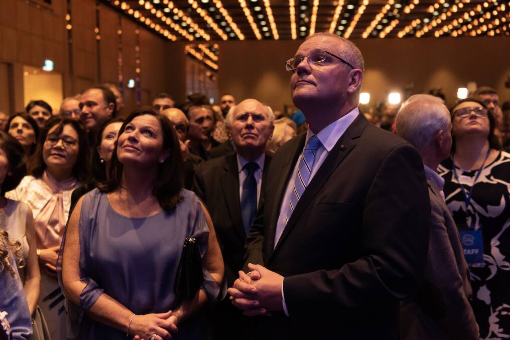 Scott Morrison and his wife Jenny, with former prime minister John Howard, watch a TV as NSW Labor leader Michael Daley concedes defeat.