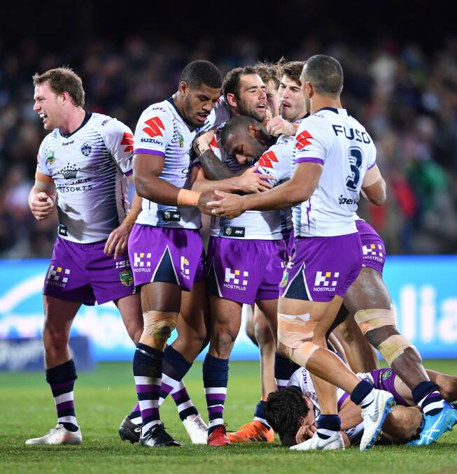 Big play: Storm captain Cameron Smith (centre) reacts with teammates after kicking the match-winning field goal. Photo: AAP
