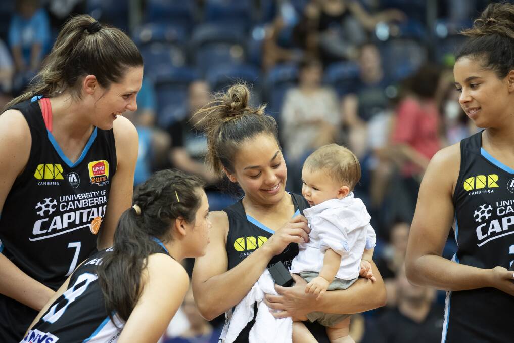 The Canberra Capitals' Lauren Scherf, Abby Cubillo, and Hannah Young share the moment with Leilani Mitchell's son Kash after winning the 2018-19 WNBL championship. Photo: Sitthixay Ditthavong