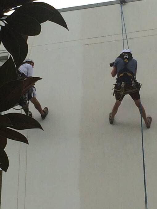 The Canberra Times photographer Jay Cronan joins the abseiling painters. Photo: Megan Doherty
