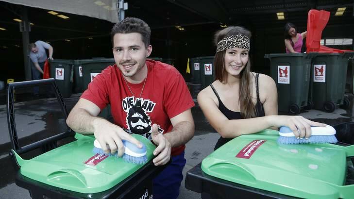 University of Canberra Rotaract members Casper Tucker from Belconnen, Emma Bell from Murrumbateman cleaning bins to raise money for elephants in Cambodia through the Rotary Club of Hall's Capital Region Farmers Market. Photo: Jeffrey Chan
