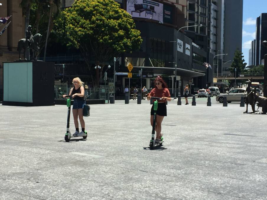 Lime scooter riders risk brain injury and death while zipping around without helmets on in Brisbane city. Photo: Tony Moore