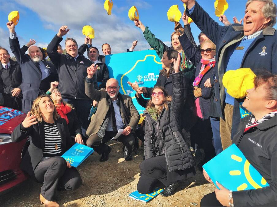 Local government leaders from 35 towns and cities across Australia toss their hats at the Cities Power Partnerships launch at Mt Majura Solar Farm in Canberra on Wednesday. Photo: Katie Burgess