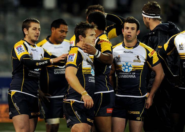 A shattered Zack Holmes is comforted by Brumbies teammates after his penalty miss against the Reds. Photo: Colleen Petch