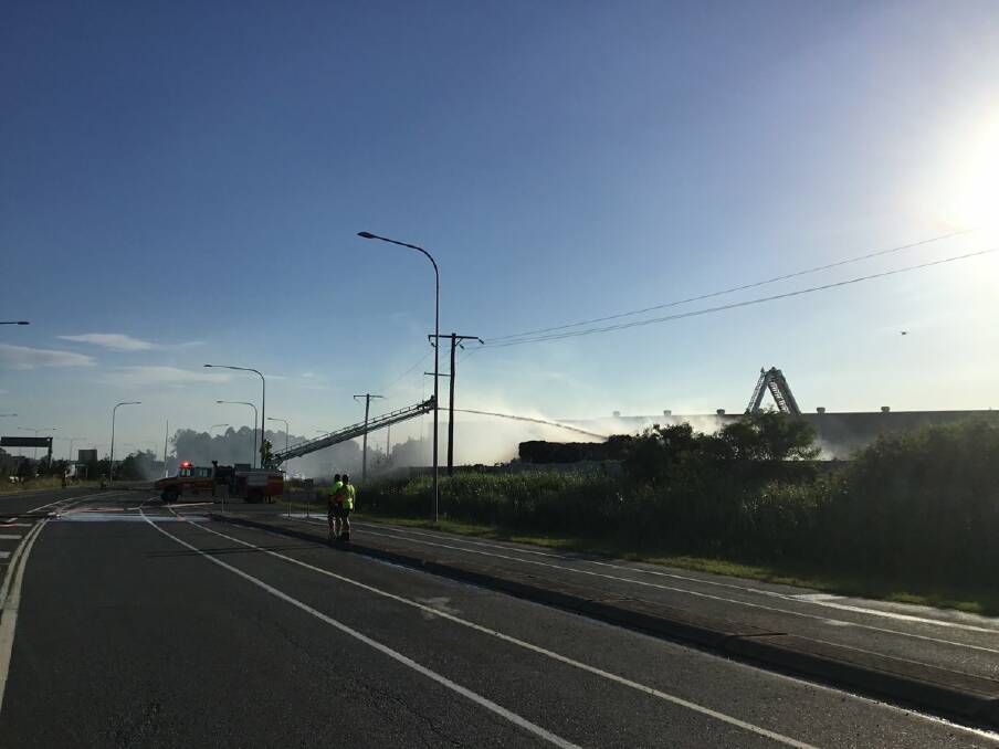Firefighters work to extinguish a fire at Lytton Road near the Port of Brisbane which forced the road to close. Photo: Queensland Ambulance Service