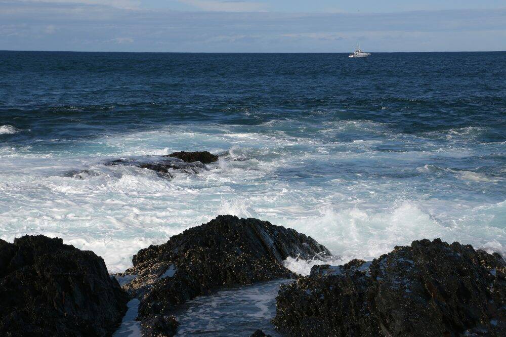 Looking for debris: A search boat off the coast on Monday afternoon.  Photo: Jeffrey Chan
