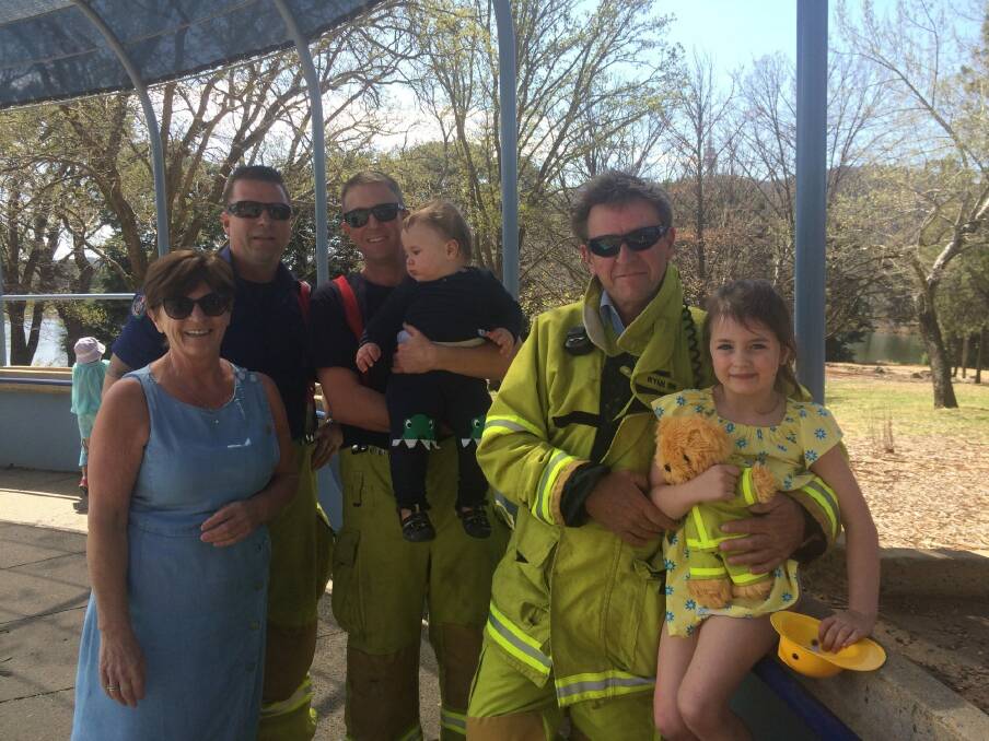 ACT Fire and Rescue officers Phil Levings, Paul Bunfield and Shane Ryan following their rescue of five-year-old Emiliana Barry, who became stuck in play equipment at Weston Park in September. She is pictured with her baby brother, Arthur and grandmother, Pauline.