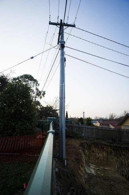 The power pole that became unstable after excavation commenced. A geotechnical assessment  has since found no safety issues although the concrete block remains. Photo: Dion Georgopoulos