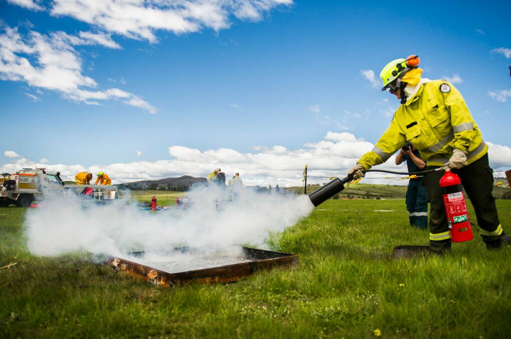 After... Elle Saber demonstrates putting out a small fire using a fire extinguisher. Photo: Rohan Thomson