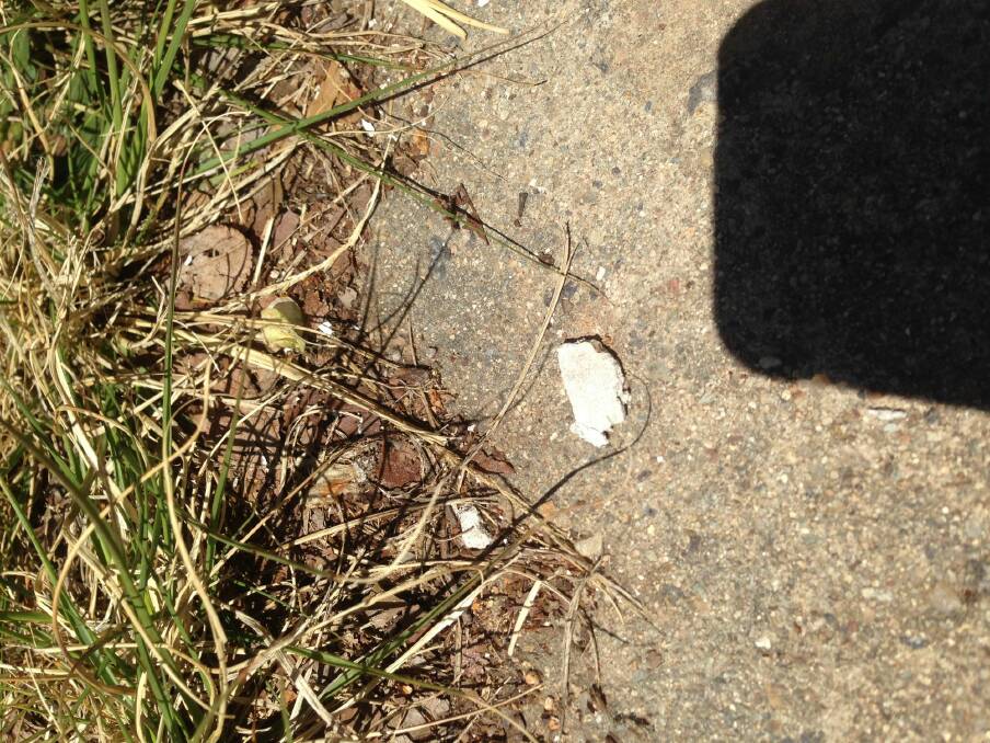 Fragments believed by neighbours to be asbestos on the footpath outside the Chifley property on Wednesday afternoon.  Photo: Supplied