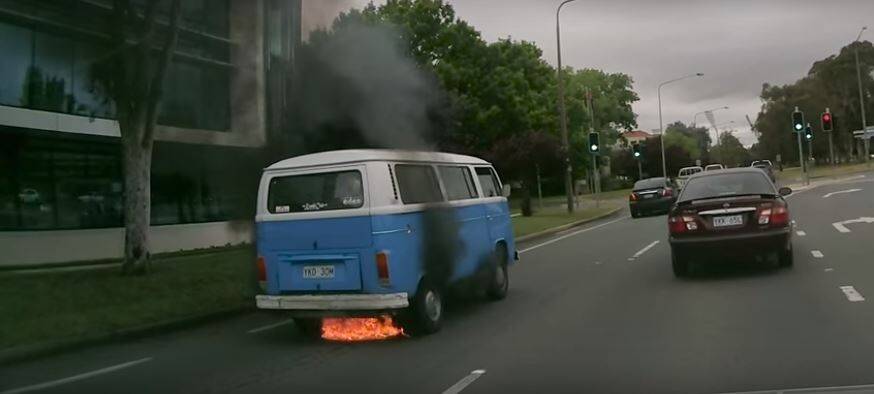 A Kombi van burst into flames at the intersection of Canberra Avenue and National Circuit during peak hour traffic on Tuesday. Photo: Screenshot/Bernard Pearson