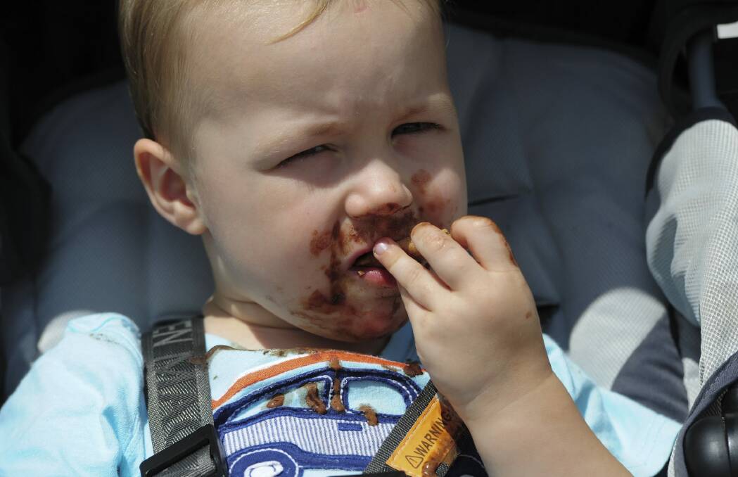 Blake Robinson, 2, of Watson, enjoys a chocolate icecream. Photo: Graham Tidy