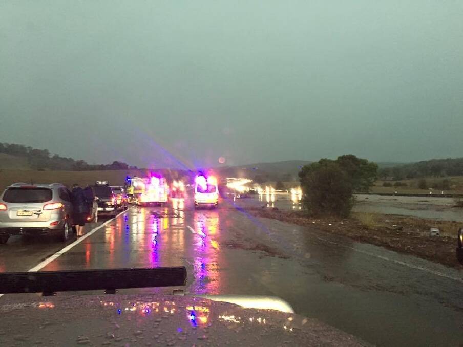 Emergency crews respond to cars swept off the Federal Highway due to flooding. Photo: Tom Corra