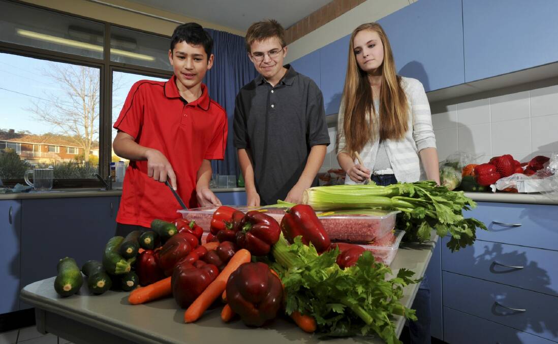 Youth from The Church of Jesus Christ of Latter Day Saints in the church’s kitchen in Garran. From left; Cormack Kikkert, 13, of Charnwood, Joshua Welling, 13, and Evelyn Welling, 15, both of Isaacs.  Photo: Graham Tidy