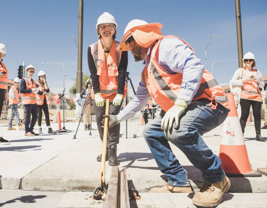 Minister for Transport Meegan Fitzharris helping install the last section of rail along the Gungahlin to the city Light Rail corridor on Friday. Photo: Jamila Toderas