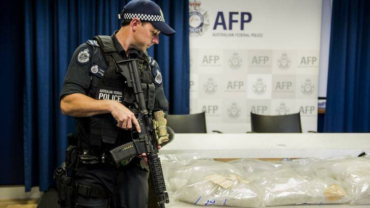 28kg: An armed police officer stands guard over one of the ACT's largest drug seizure of methamphetamine. Photo: Jay Cronan