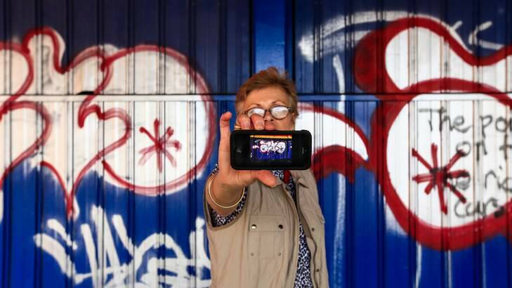 CEO of CBD limited Jane Easthope takes a photo of graffiti using the new iPhone app vandal trak which aims to help stop vandalism graffiti around Canberra. Photo: Katherine Griffiths