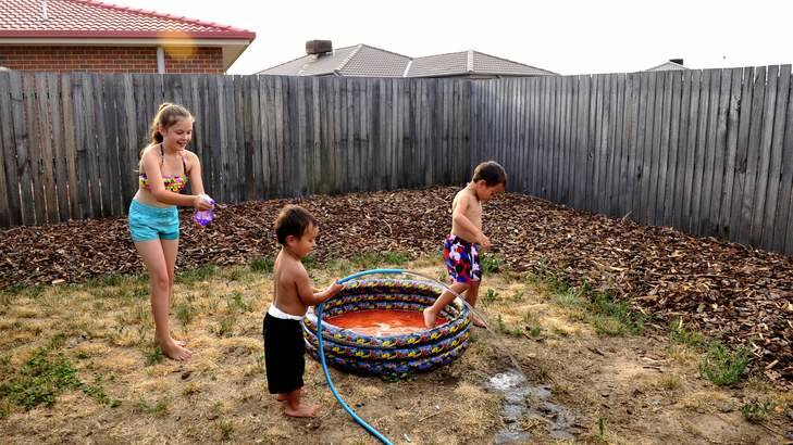 Studies have shown that the suburb of Macgregor was up to 7 degrees hotter than certain southside suburbs. L-R Aideen Fitzgerlad,9,  cools off with Nate Fitzgerald,2,  and Seth Fitzgerald,5  in their backyard in Macgregor. Photo: Melissa Adams