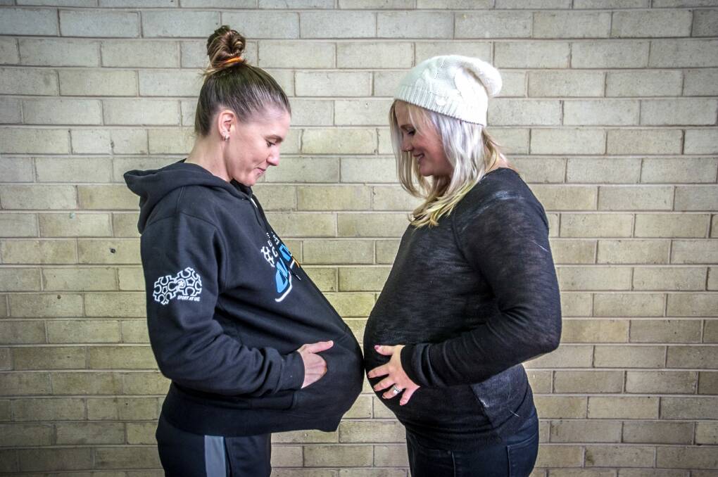 Nat Hurst (left) has returned to play with the Canberra Capitals pictured with her wife Tara Hurst who is 39 weeks pregnant.  Photo: karleen minney