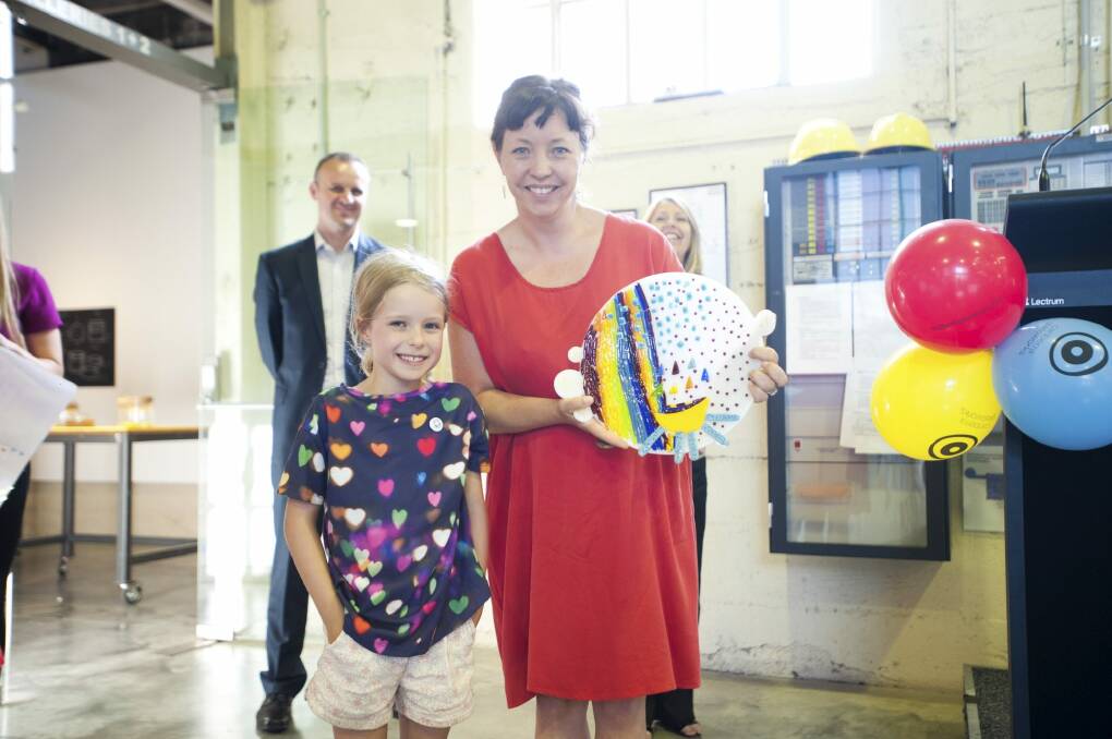 Audrey Hickman, 7, with her winning design from the The Canberra Times Kids' Glass Design Competition at the Canberra Glassworks, and artist Lisa Cahill.  Photo: Daniel Spellman