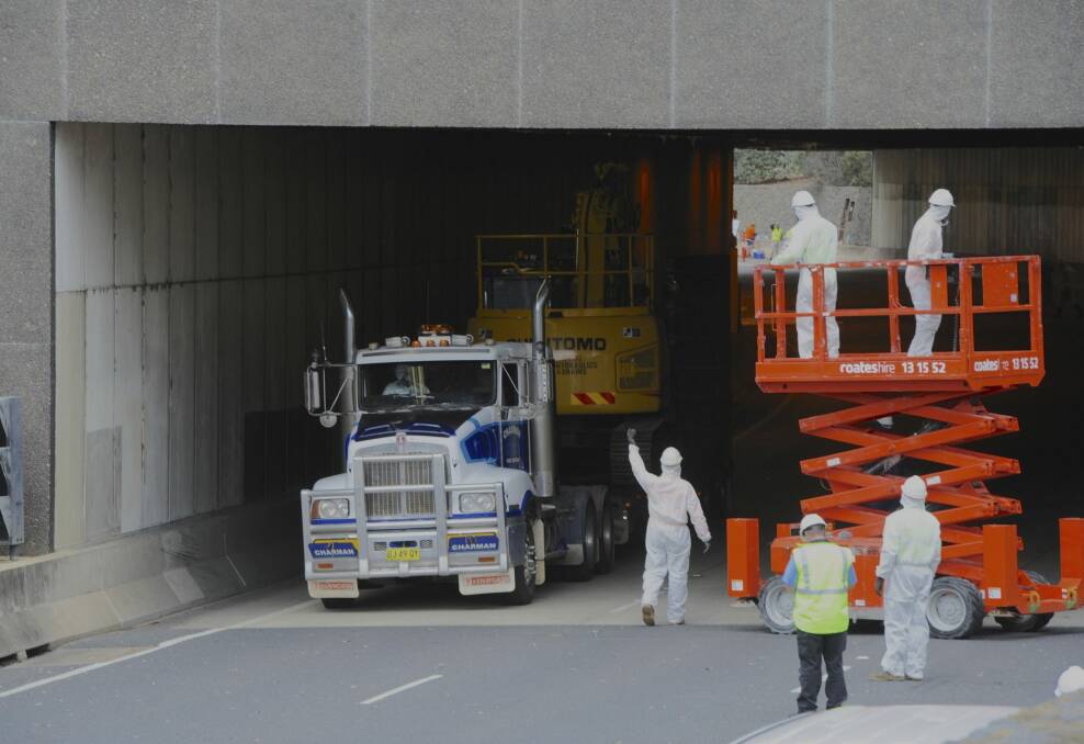 The low loader and excavator are driven out of the Acton tunnel
on Parkes Way. Photo: Graham Tidy
