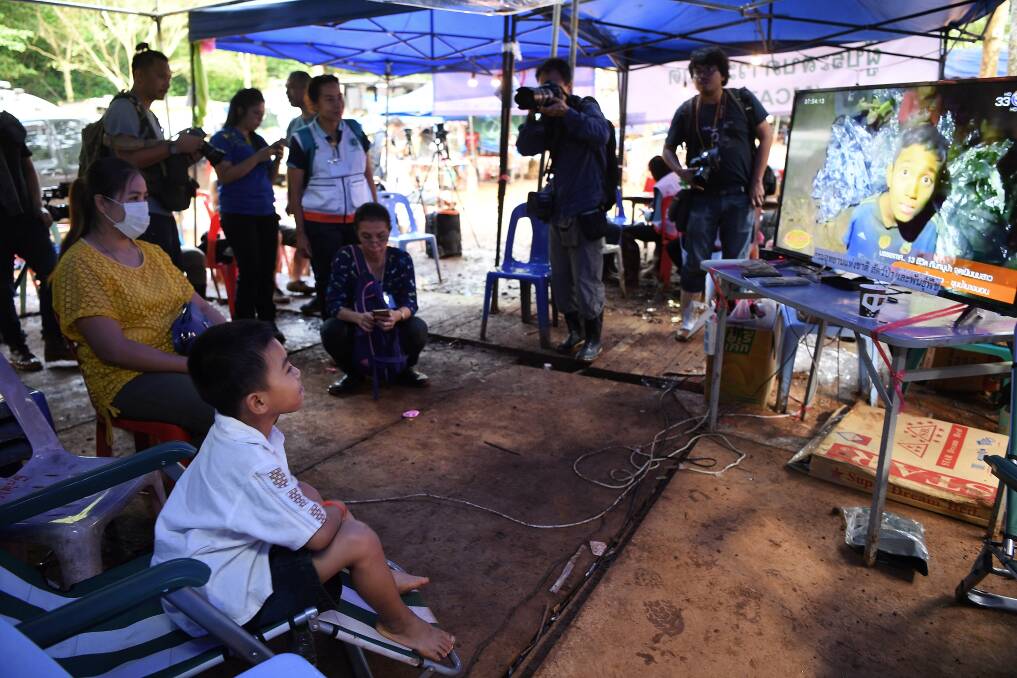 Beam Wongsookjan, 5, second from left,  watches footage of his older brother and the other boys. Photo: Kate Geraghty