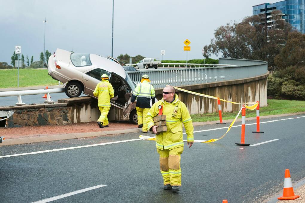 Emergency service personnel attend the crash on the Commonwealth Avenue on-ramp. Photo: Dion Georgopoulos