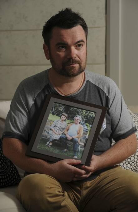 John Mikita in his Gungahlin home with a picture of his treasured grandparents. Photo: Graham Tidy