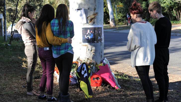 School friends gathered at the tree where the car hit. Photo: Graham Tidy