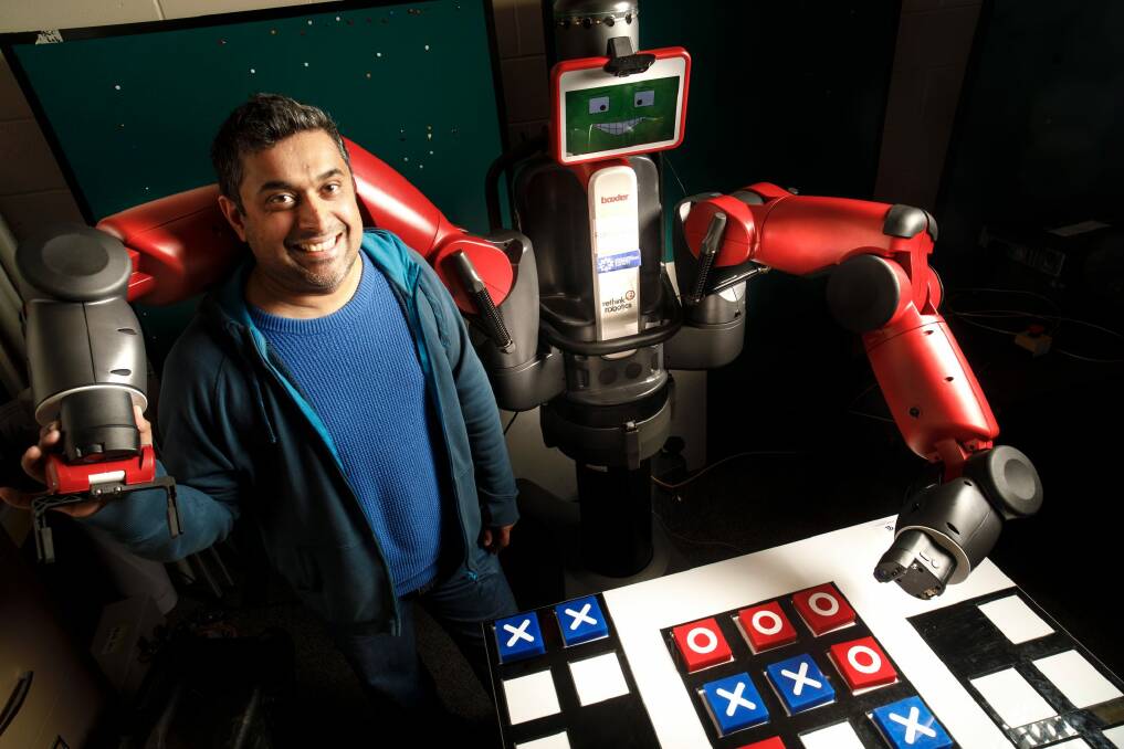 University of Canberra researcher Damith Herath with his robot Baxter, who has been taught to cheat at tic tac toe.  Photo: Sitthixay Ditthavong
