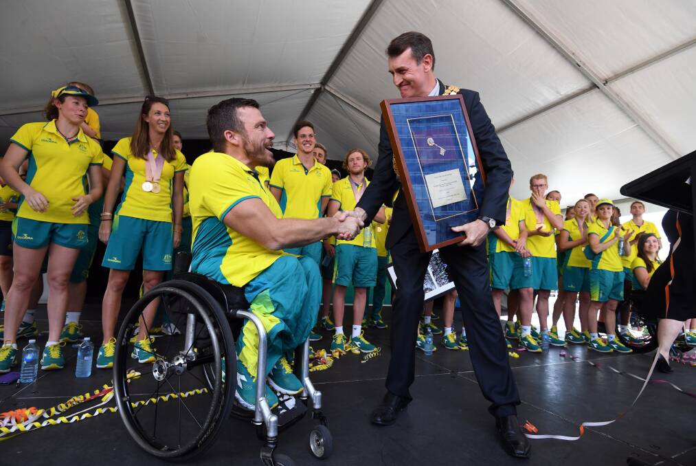 Lord Mayor Graham Quirk gives wheelchair gold medallist and crowd favourite Kurt Fearnley the keys to the City of Brisbane. Photo: Dan Peled/AAP